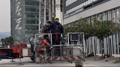 Bursa’da özel bir hastanenin dış cephe camlarını silen 2 işçi,