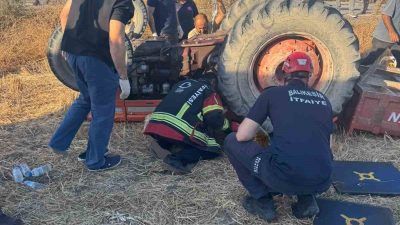 Balıkesir’in Altıeylül ilçesinde otomobil ile kaza yaparak, devrilen traktörün altında